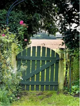  ??  ?? The gate from the herb garden into the surroundin­g fields is surrounded by fennel, Achillea millefoliu­m and roses. ›