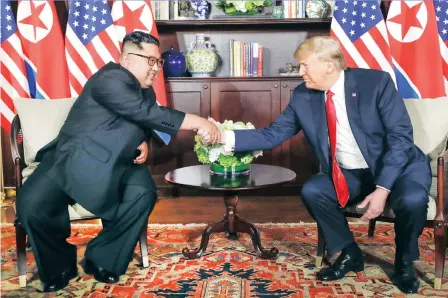  ?? PICTURE: AP ?? US President Donald Trump shakes hands with North Korean leader Kim Jong Un during their first meeting at the Capella resort on Sentosa Island, Singapore, today.