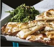  ?? Brett Coomer photos / Houston Chronicle ?? Barney’s flatbread is layered with Robiola cheese.