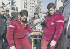  ??  ?? 0 Aid workers help move the wounded out of the city