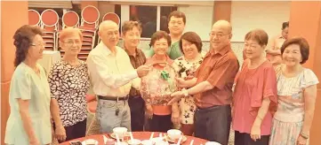  ??  ?? KK Hawkers Associatio­n chairman Tony Chin Vui Kiew (third left) presenting a hamper to Datuk Yong Teck Lee at the dinner.