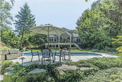  ??  ?? The brick-and-stone home has welcoming wide front steps and double doors. Out back, a covered deck provides an optimal spot for dining, or to enjoy a view of your new house, you can move to the poolside patio table.