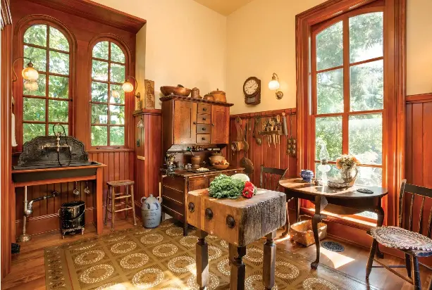  ??  ?? REPRODUCTI­ONS OF THE 1861 WINDOWS TIE THE KITCHEN ADDITION TO THE ORIGINAL HOUSE. A HAND-PAINTED FLOORCLOTH, FOUND ON E-BAY, PROTECTS THE KITCHEN’S WOOD FLOORS. AN OLD BUTCHER BLOCK ACTS AS A PREP ISLAND, AND AN EARLY HOOSIER CABINET IN ITS ORIGINAL...
