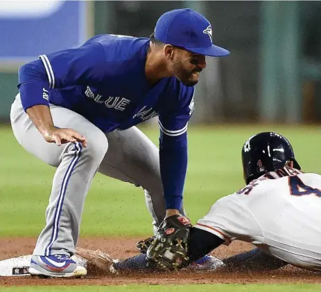  ?? ERIC CHRISTIAN SMITH/THE ASSOCIATED PRESS ?? Astros baserunner George Springer beats the tag at second base by Blue Jay Devon Travis in the first inning of Monday night’s series opener.