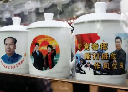  ?? (Tyrone Siu/ Reuters) ?? SOUVENIR CUPS with images of late Chairman Mao Zedong (left) and President Xi Jinping are seen at a shop in Beijing, last month.