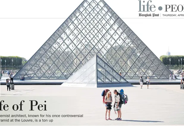  ??  ?? Tourists stand in front of the Louvre Pyramid.