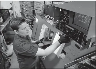  ?? AP/RICH PEDRONCELL­I ?? Kyle Chittock sets up a computeriz­ed lathe at his family’s manufactur­ing business, Simply Country, in Grass Valley, Calif., earlier this month.