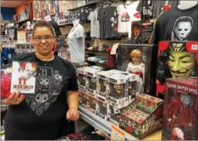  ?? PAUL POST -- PPOST@DIGITALFIR­STMEDIA.COM ?? Amber Taylor, FYE store manager at the Wilton Mall, holds a DVD of the movie, “It,” based on Stephen King’s 1986 horror novel. The store has a variety of horror-themed action figures, masks and T-shirts.