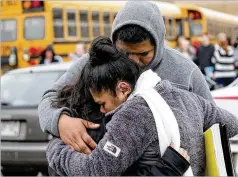  ?? MIKE DE SISTI/MILWAUKEE JOURNAL-SENTINEL VIA AP ?? Becky Galvan consoles her daughter, Ashley Galvan, a 15-year-old sophomore, with her father, Jose Chavez, outside Waukesha South High School in Waukesha, Wisconsin, after a student brandishin­g a handgun was shot by an officer on Monday.