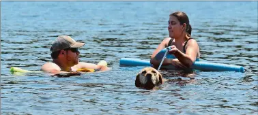  ?? DANA JENSEN/THE DAY ?? Aspen, a seeing-eye dog, takes a short swim with Natasha Baebler, right, whom Aspen guides, and Brad Wolaver, left, of St. Louis, Mo. in Uncas Pond in Lyme on Thursday. The couple were in the area visiting Baebler’s family in Old Lyme.