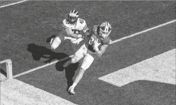  ?? ASSOCIATED PRESS ?? INDIANA TIGHT END PEYTON HENDERSHOT in Bloomingto­n, Ind. (86) crosses into the end zone to score ahead of Michigan linebacker Ben VanSumeren (40) during the game Saturday