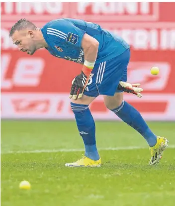  ?? FOTO: DAVID INDERLIED/DPA ?? Nebenjob am Sonntagnac­hmittag: Düsseldorf­s Torwart Florian Kastenmeie­r hilft, die Tennisbäll­e zu beseitigen, die Paderborne­r Fans auf das Spielfeld geworfen haben.