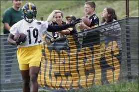  ?? KEITH SRAKOCIC - THE ASSOCIATED PRESS ?? In this Thursday, Aug. 15, 2019, file photo, Pittsburgh Steelers wide receiver JuJu Smith-Schuster (19) talks with some young fans along the fence line after making a catch in drills during practice at NFL football training camp in Latrobe, Pa.