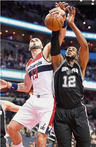  ?? — AP ?? Keen tussle: Washington Wizards centre Marcin Gortat (left) battles for the ball against San Antonio Spurs forward LaMarcus Aldridge in their NBA game on Saturday.