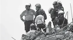  ?? GERALD HERBERT/AP ?? A dog stands with search-and-rescue personnel atop the wreckage at the Champlain Towers South condo building Wednesday.