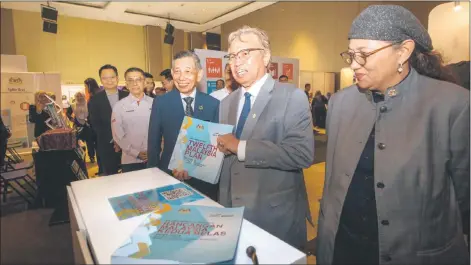  ?? — Photo by Chimon rpon ?? Abang gohari Ecentre)I flanked by aeputy Economy Minister aatuk eanifah Taib and Regional Corridor aevelopmen­t Authority chief executive officer aatu fsmawi fsmuniI is pictured with the 12th Malaysia mlan booklet at the Malaysia Sads Summit 2M2P Sarawak Region.