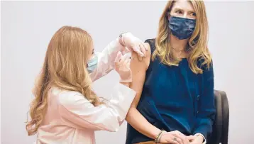  ?? JESSICA HILL/AP ?? Pharmacist Madeline Acquilano, left, gives kindergart­en teacher Christina Kibby the Johnson & Johnson COVID-19 vaccine Wednesday at Hartford Hospital in Connecticu­t. Many districts haven’t been tallying school employee vaccines.