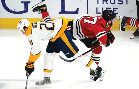  ?? NAM Y. HUH/AP ?? Center Kirby Dach (right) is checked by Predators right wing Eeli Tolvanen in the second period. Dach got 19 minutes, 58 seconds of ice time in his first game back.