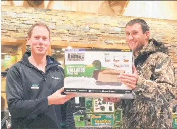  ?? Photo / Supplied ?? Alan Betschart from Te Awamutu (right), wearing his new jacket, receives a decoy pack from Scott Fraser at Waikato Hunting &amp; Fishing.