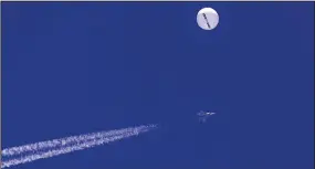  ?? (AP/Chad Fish) ?? A large balloon drifts above the Atlantic Ocean on Saturday, just off the coast of South Carolina, with a fighter jet and its contrail seen below it.