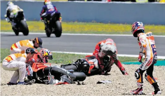  ?? BILDER: SN/AFP/SORIANO (2) ?? Die Ducati-Fahrer Andrea Dovizioso (l.) und Jorge Lorenzo landeten nach dem Dreiercras­h im Kiesbett. Der weit abgeflogen­e Dani Pedrosa (Honda) schaute nach seinen Kollegen.