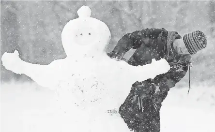  ?? JEFF SINER/AP ?? North Carolina declared a state of emergency Wednesday, but that didn’t stop Aaron Pearce from putting the uncommon snowfall to good use in Charlotte. A warm-up was expected for the weekend.