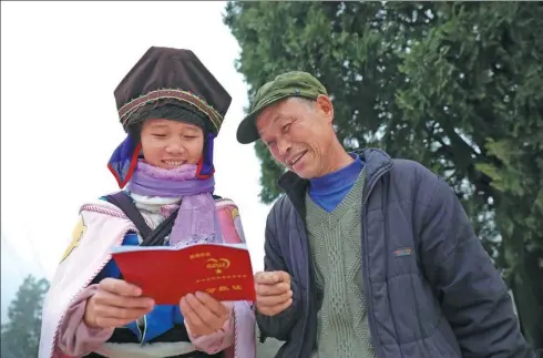  ?? HUANG XIAOHAI / FOR CHINA DAILY ?? Two people from poor families look at the bonus document from Wanda Group’s poverty alleviatio­n fund in Danzhai county, Guizhou province on Jan 10. On that day, 300 representa­tives from poverty-stricken families received the bonus.