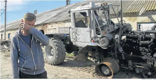  ?? SERGEY KOZLOV / EFE ?? Un hombre llora al contemplar su tractor destrozado en una granja de Mala Rohan, cerca de Jarkov.