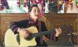  ?? LIN YIGUANG / XINHUA ?? Li Naluo sings with a guitar in Laodabao, Lancang county in Yunnan province.