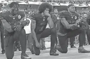  ?? AP FILE ?? Colin Kaepernick, middle, along with San Francisco 49ers teammates Eli Harold, left, and Eric Reid, kneel in protest during the playing of the national anthem before a home game against the Arizona Cardinals on Oct. 6, 2016.