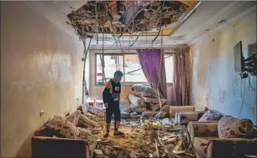  ?? AFP ?? A Palestinia­n child stands in the living room of a building that was damaged during Israeli bombardmen­t in Rafah, on the southern Gaza Strip, on Saturday, amid ongoing battles between Israel and Hamas.