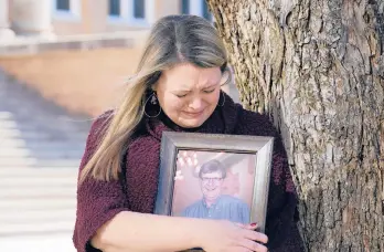  ?? GUTIERREZ/AP TONY ?? Katie Riggs Maxwell hugs a portrait of her father, Mark Riggs, this month on the campus of Abilene Christian University in Abilene, Texas. Mark Riggs, who was a professor at the school, died of COVID-19.