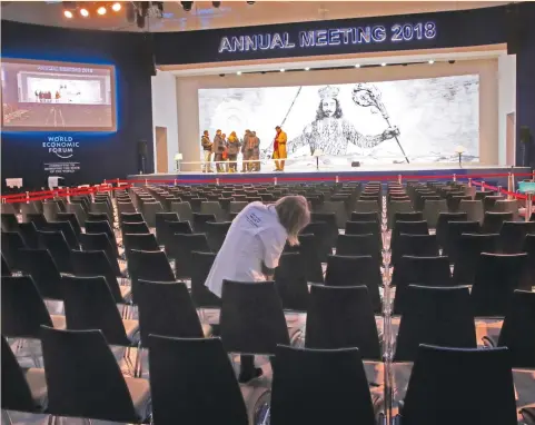  ?? (Denis Balibouse/Reuters) ?? A STAFF MEMBER cleans chairs in Congress Hall ahead of the World Economic Forum annual meeting in Davos yesterday. A decade after the bankruptcy of US investment bank Lehman Brothers helped trigger a global financial crisis, economic growth has...