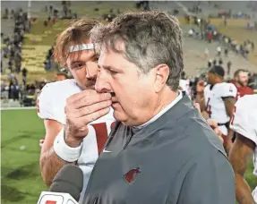  ?? DAVID ZALUBOWSKI/AP ?? Washington State quarterbac­k Gardner Minshew puts a fake mustache on head coach Mike Leach after the Colorado game.