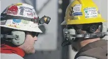  ?? AP PHOTO/BRENNAN LINSLEY ?? Encana Corp. workers discuss a well pad near Mead, Colo. Shares in the company rose Friday after it released improved earnings figures that exceeded expectatio­ns.