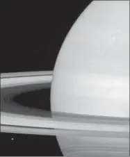  ?? NASA/JPL-CALTECH/SPACE SCIENCE INSTITUTE VIA AP ?? This undated photo made available by NASA shows one of Saturn’s moons, Mimas, dwarfed by the planet’s rings. Launched in 1997, Cassini reached Saturn in 2004and has been exploring it from orbit ever since. Cassini’s fuel tank is almost empty, so NASA...