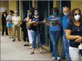  ?? JOHN MCDONNELL — THE WASHINGTON POST ?? Alexandria residents wait in a socially distanced line to cast their ballots for the November presidenti­al election on first day of early voting in Virginia at the Voter Registrati­on Office in Alexandria, Va.