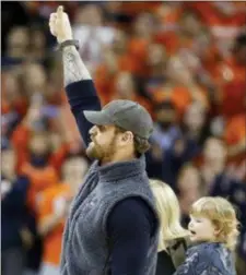  ?? STEVE HELBER — THE ASSOCIATED PRESS ?? Former Virginia football player and current Eagle Chris Long, gives a thumbs up to the crowd as he is introduced during the first half in Charlottes­ville, Va., on Saturday.