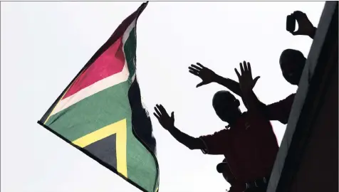  ?? PHOTO: REUTERS ?? In this file photo, a man waves a South African flag after the death of former President Nelson Mandela. The country has come a long way from the moral high ground it enjoyed, says the writer.