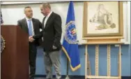  ?? MATT ROURKE — THE ASSOCIATED PRESS FILE ?? In this file photo, John Grant, right, shakes hands with FBI Special Agent Jacob Archer, left, after taking custody of a recovered Norman Rockwell painting stolen during a 1976 break-in at the Grant family’s home in Cherry Hill, N.J., at a news...