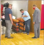  ?? (Courtesy Photo) ?? Jarod Morrison (left), Farmington schools’ maintenanc­e supervisor, and Superinten­dent Jon Laffoon watch as Mark Elliott with Eason Freedom takes swabs from the surface of these basketball­s. Elliott then will use a meter to test the swab for evidence of virus and/or bacteria cells. The School District is contractin­g with Eason Freedom this year to come in and test as an extra layer of protection for school and staff.