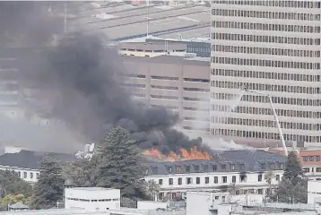  ?? GIANLUIGI GUERCIA/GETTY-AFP ?? The fire that had already destroyed South Africa’s main Parliament chamber in Cape Town flared up again Monday about 36 hours after it started in the 130-year-old complex of historic buildings, authoritie­s said. The fire, which had been put out, is under investigat­ion. A man was arrested Sunday at the scene and will appear in court Tuesday.