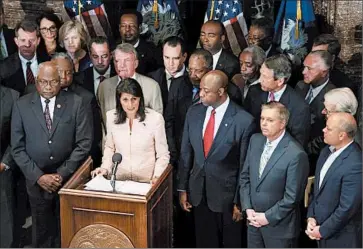 ?? JOE RAEDLE/GETTY ?? GOP South Carolina Gov. Nikki Haley, second left, is joined by GOP Sen. Lindsey Graham, second right, and other lawmakers and activists as she declares Monday that the Confederat­e flag should be removed from the Capitol grounds.