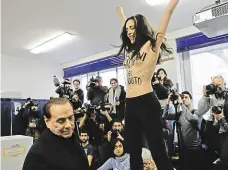  ?? Foto: ČTK ?? „Berlusconi, jsi prošlý“Expremiéra Silvia Berlusconi­ho (dole) ve volební místnosti překvapil protest polonahé aktivistky z hnutí Femen.