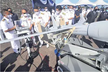  ??  ?? Mohd Reza (third left) being briefed by Navy officers on the UAS ScanEagle during the launch of 601 Squadron at the Sepanggar Naval Base yesterday.