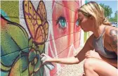  ?? JESSICA SURIANO/THE REPUBLIC ?? Nyla Lee, 21, adds detail to a flower on a mural for a house’s backyard. A couple of her larger murals can be found scattered around downtown Phoenix.