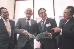  ??  ?? From left: Non-independen­t non-executive director Tengku Zahaimi Tuan Hashim, Abdul Rahim, chairman and independen­t non-executive director Datuk Ahmad Ibnihajar and non-independen­t non-executive director Tunku Alizan Raja Muhammad Alias sharing a light...