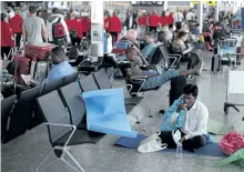  ?? DANIEL LEAL-OLIVAS/GETTY IMAGES ?? A passenger rests on the floor at London’s Heathrow Airport on Monday. Passengers faced a third day of disruption at Heathrow Monday as British Airways cancelled short-haul flights after a global computer crash.