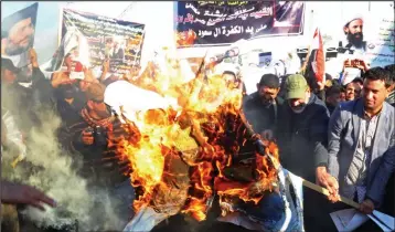  ??  ?? Rage: Iraqi Shia protesters in Baghdad burn an effigy of the Saudi king yesterday