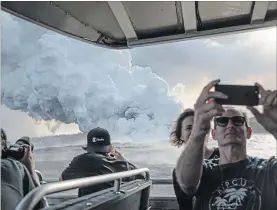  ?? TAMIR KALIFA NYT ?? Passengers take photos of a plume of volcanic gases and steam rising as lava from a Kilauea volcano fissure enters the Pacific.